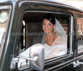 Smiling and happy bride arrives in a vintage car to her wedding, Rome