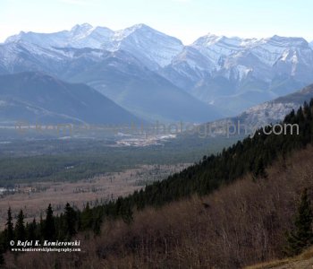Approaching Kananaskis Country. Driving west, the early morning sunlight offers a grandiose scene of undulating Foothills abruptly ending at the east slopes of the Rockies.